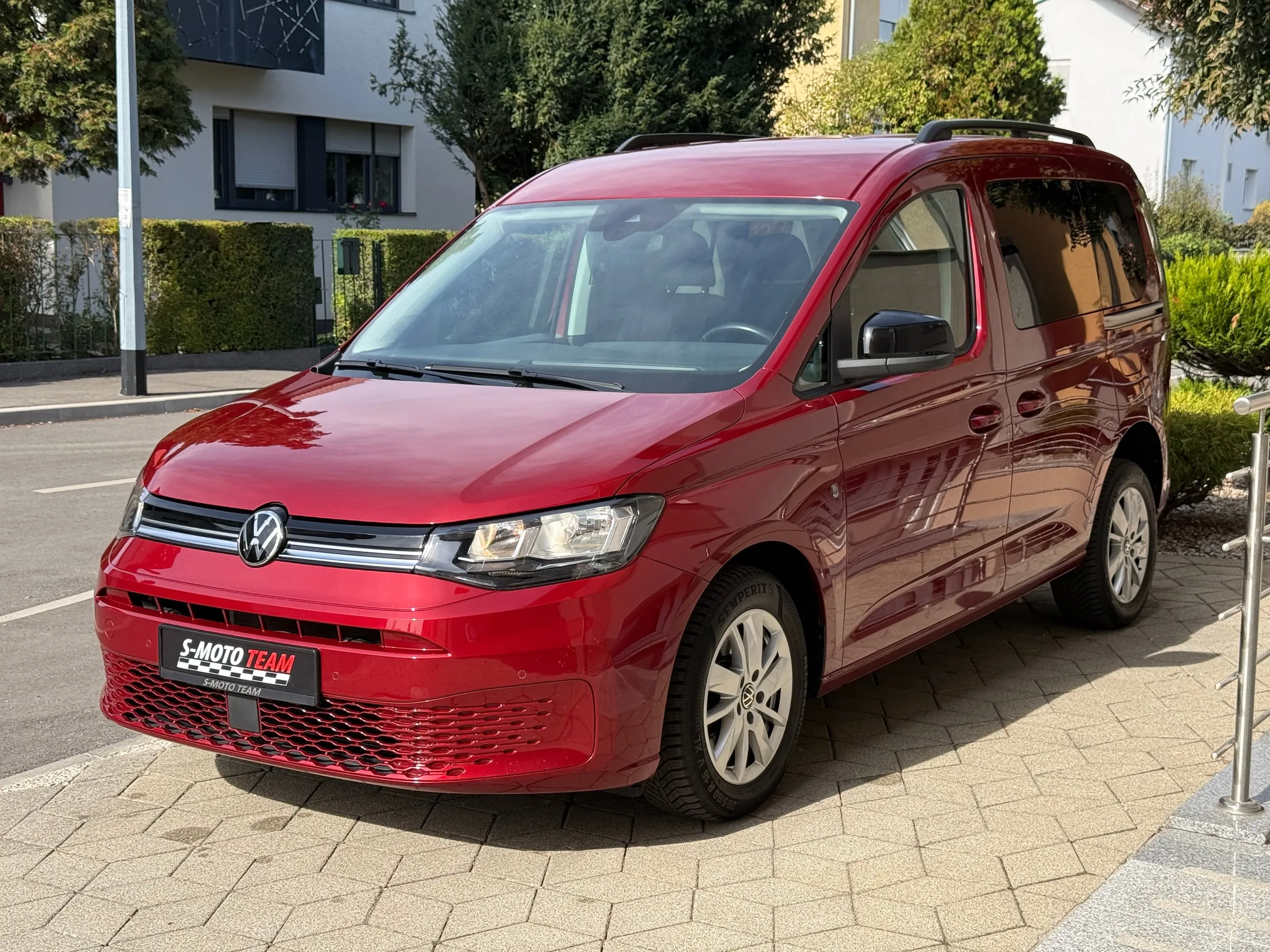 Volkswagen Caddy u crvenoj boji, prilagođen za invalidska kolica - pogled sprijeda ukoso