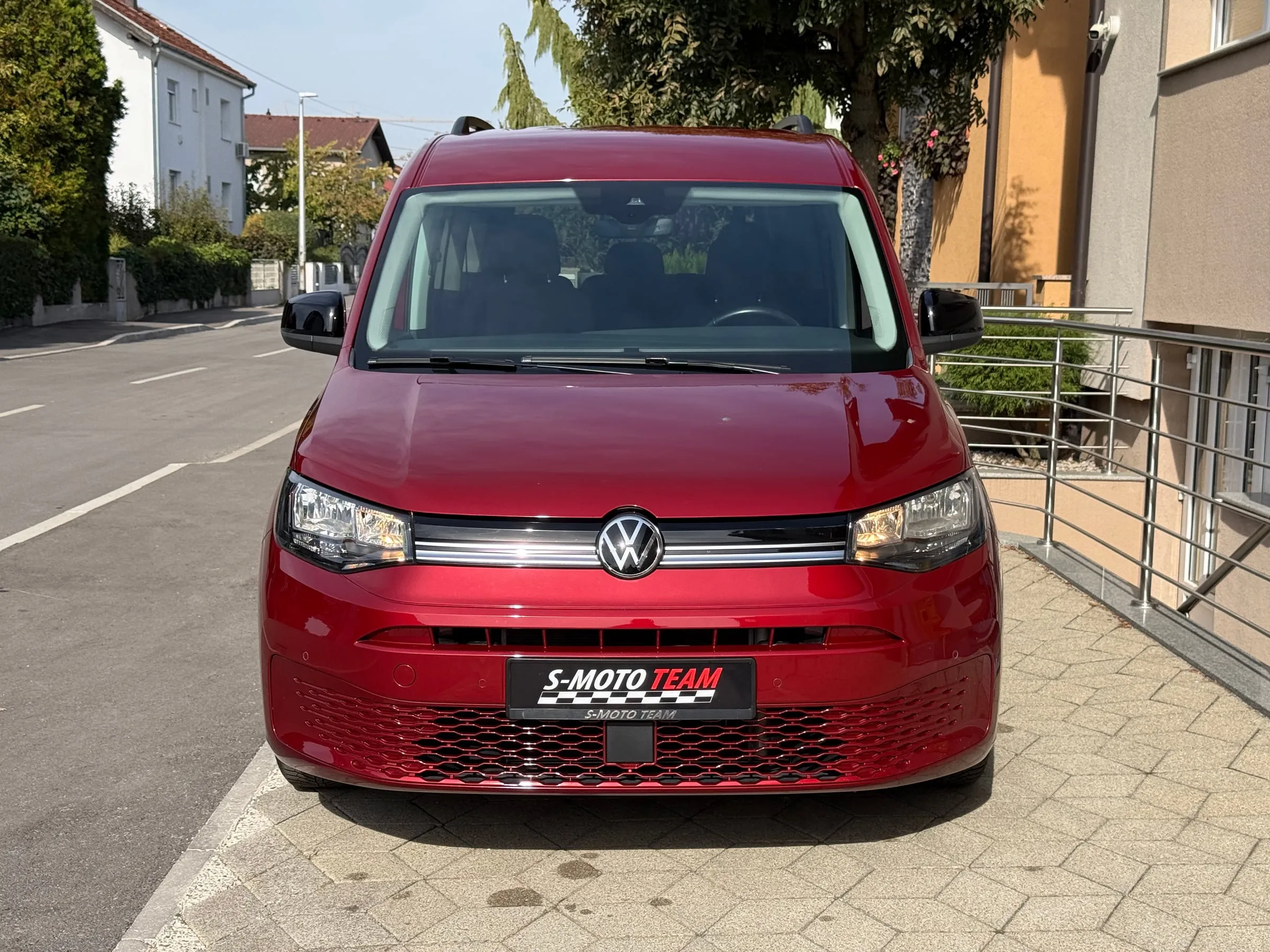 Volkswagen Caddy u crvenoj boji, prilagođen za invalidska kolica - pogled sprijeda